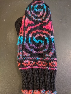 Mitten 1 The back of a brightly colored colorwork mitten