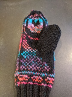 Mitten 2 The palm of a brightly colored colorwork mitten